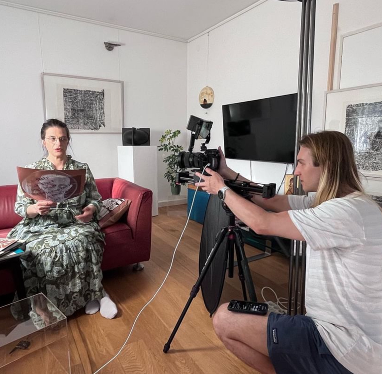 student filming writer reading her work 