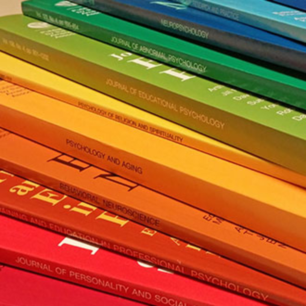 thin journals arranged on top of each other in a rainbow of different cover colors