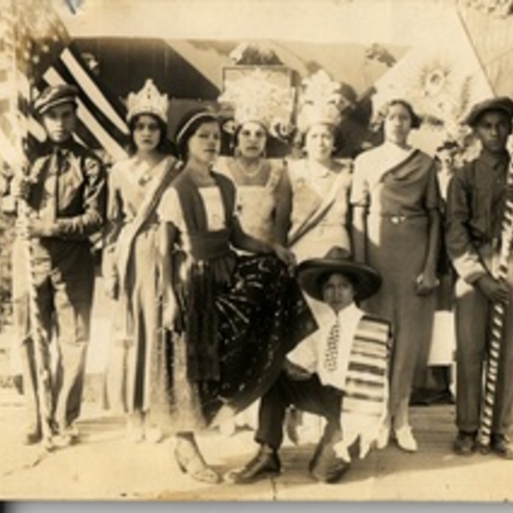 An old brownish photo of a group of women in costumes.