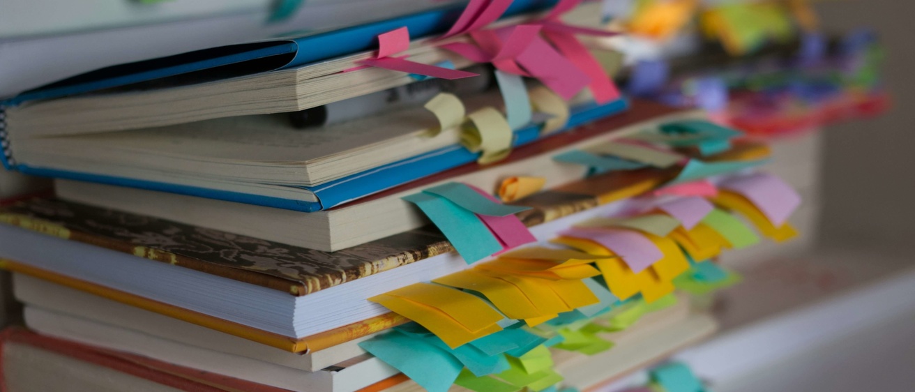 Stack of books with notes sticking out