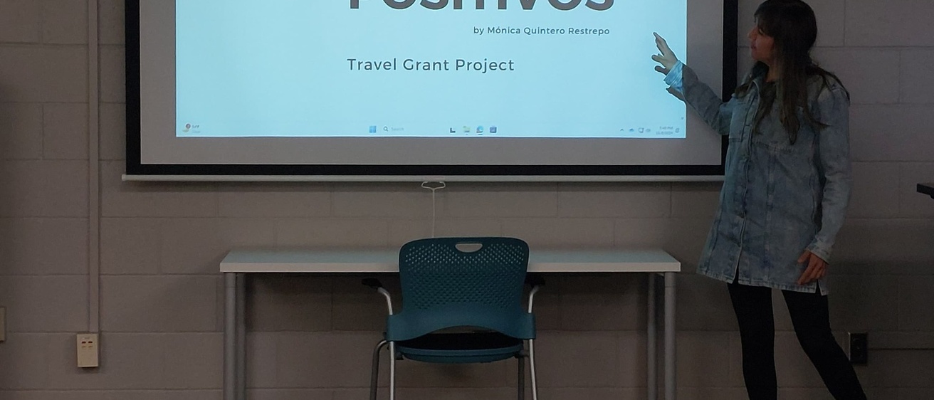A woman presenting before a projection screen in a classroom